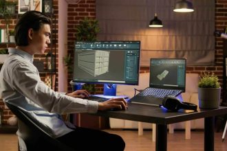 Ingénieur asiatique travaillant sur un PC industriel en milieu de fabrication