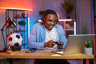 Homme noir enthousiaste portant un casque, jouant à un jeu vidéo