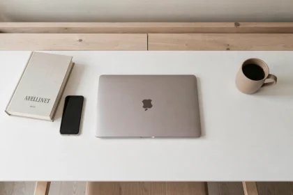 MacBook 13 pouces posé à plat sur un bureau blanc avec des objets du quotidien pour comparaison de taille