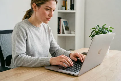 Femme utilisant un raccourci clavier sur un MacBook Pro dans un bureau minimaliste